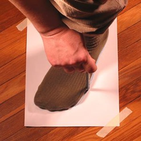 your feet on a piece of paper with a pencil